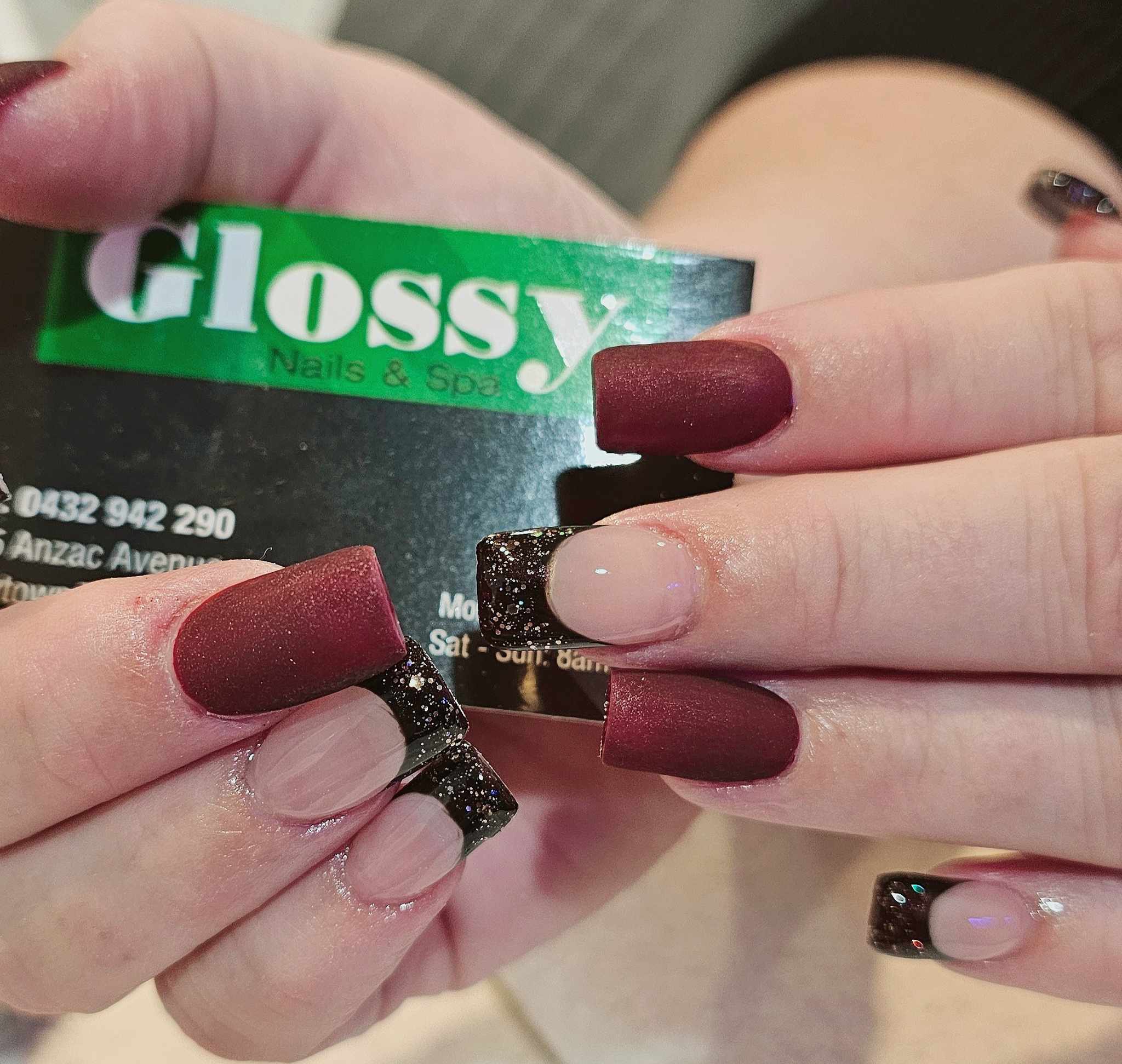 Maroon matte manicure with a black glitter accent