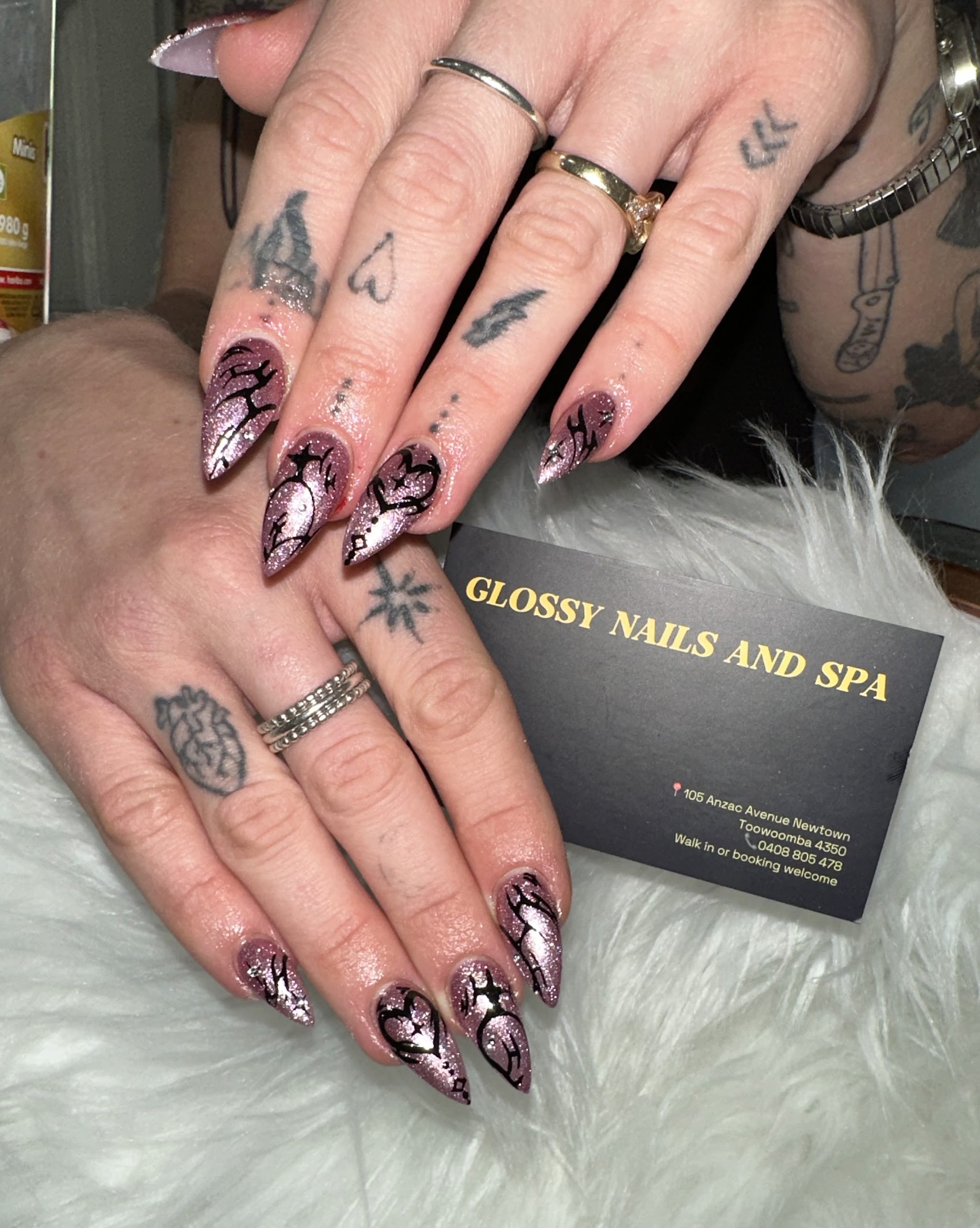 Pink glitter stiletto nails with black line art