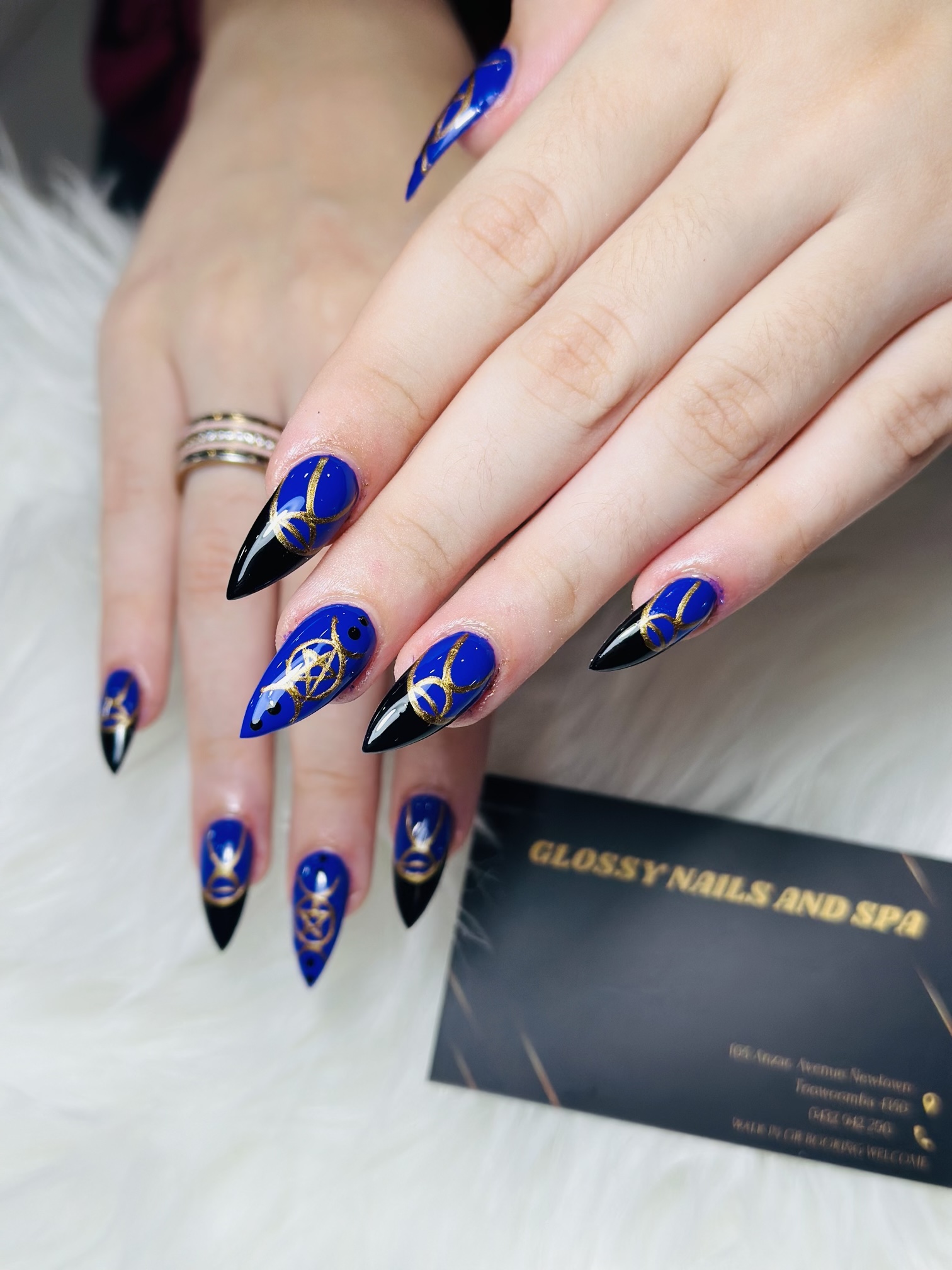 Blue and black stiletto nails with gold star art